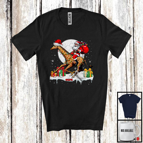 MacnyStore - Personalized Custom Name Santa Riding Giraffe; Lovely Christmas Lights Moon Santa Giraffe Lover T-Shirt