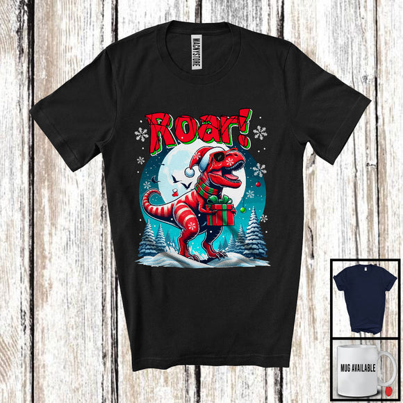 MacnyStore - Roar, Humorous Christmas Santa T-Rex Holding Box Present, X-mas Moon Dinosaur Lover T-Shirt