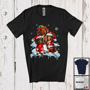 MacnyStore - Three Santa Elf Dachshunds On Snow; Adorable Christmas Snowing Dog; Family X-mas Group T-Shirt